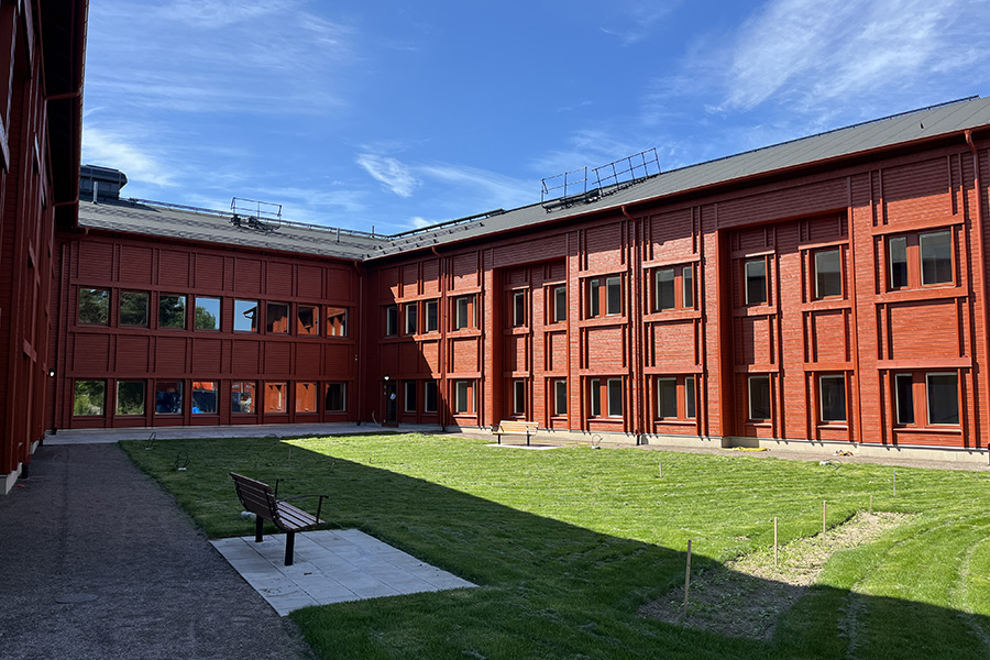 En innergård som omringas av röda fasadväggar.