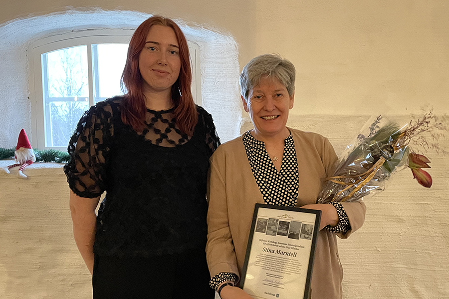 Två kvinnor står bredvid varandra och tittar in i kameran.