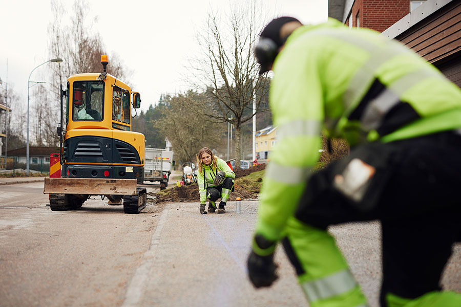 Personer i varselkläder jobbar utomhus.