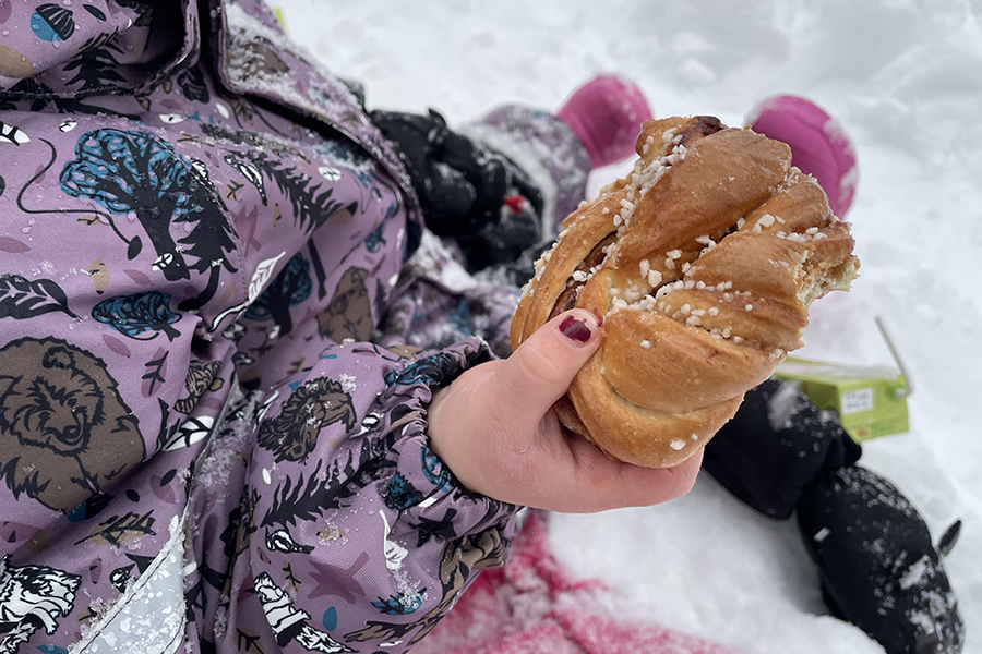 Ett barn håller en bulle i handen. 