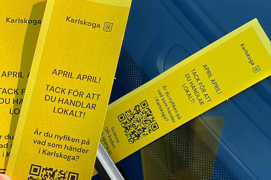 En fejkad parkeringsbot i framrutan på bil med en glad hälsning från Karlskoga kommun.