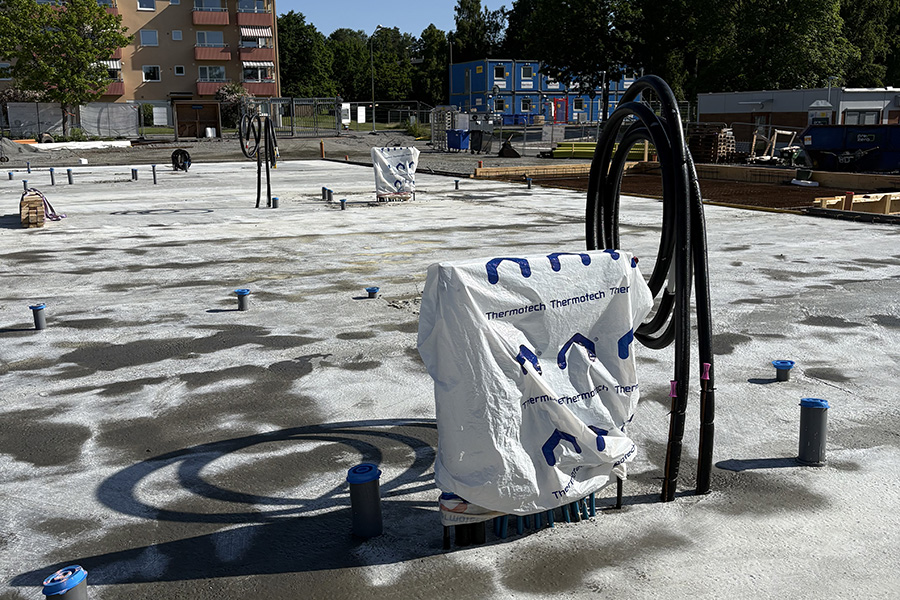 Byggarbetsplats med gråa rör och vadderad utrustning.