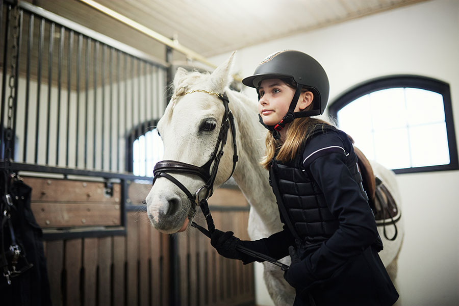 Ett tennisrack i närbild. Framför ligger en tennnisboll. 
