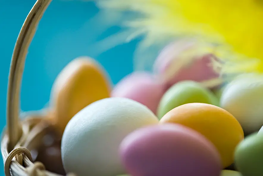 Ett tennisrack i närbild. Framför ligger en tennnisboll. 