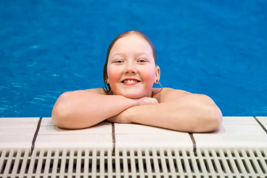 Ett tennisrack i närbild. Framför ligger en tennnisboll. 