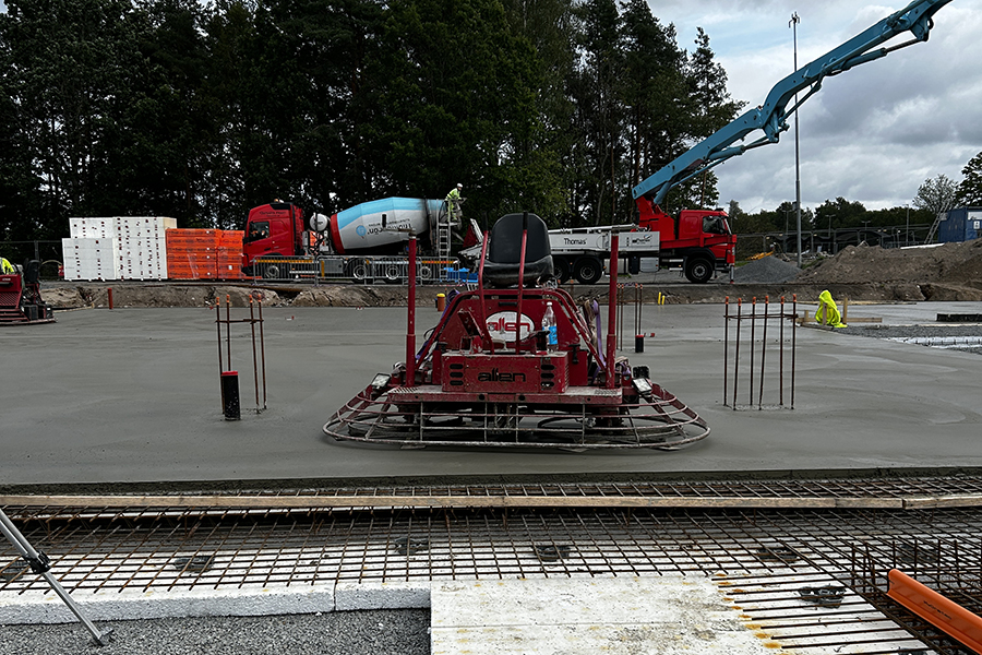 En byggarbetsplats med en arbetsmaskin i mitten av bilden. 