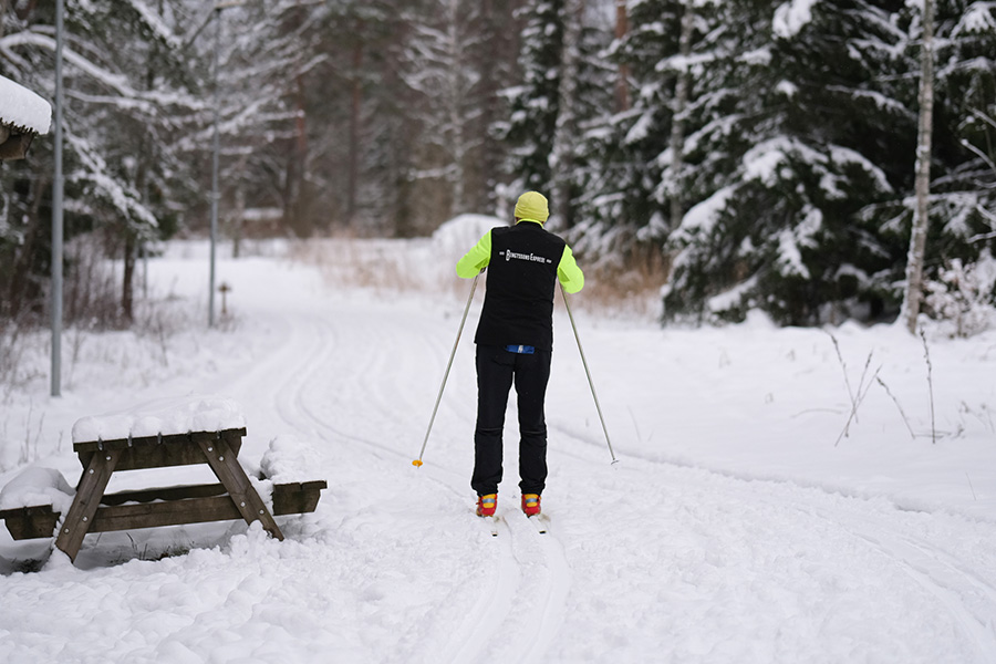 Ett tennisrack i närbild. Framför ligger en tennnisboll. 