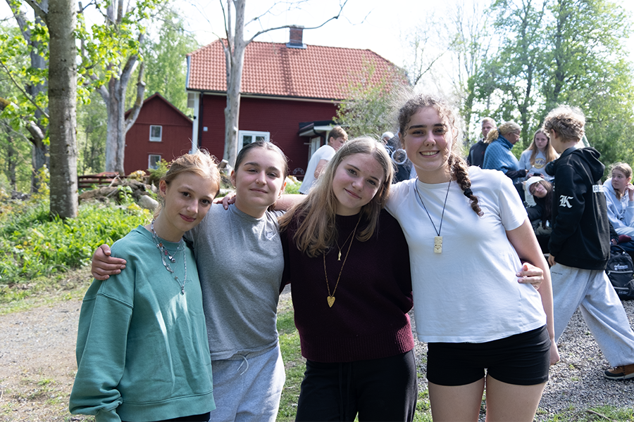 En grupp tjejer står ute i i skogen.