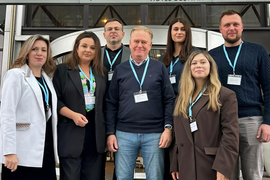 Sju personer står uppställda bredvid varandra och tittar in i kameran. 