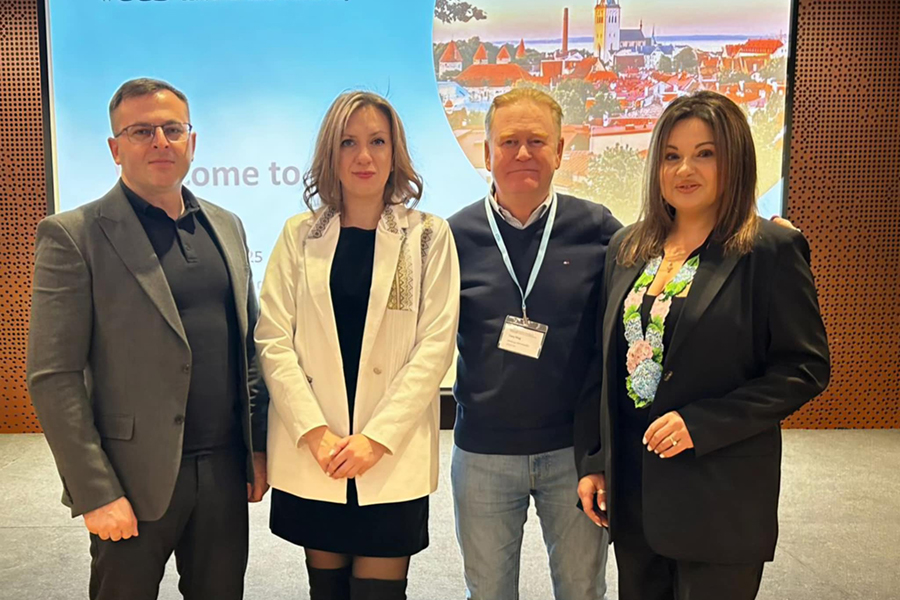 Fyra personer står bredvid varandra och tittar in i kameran.