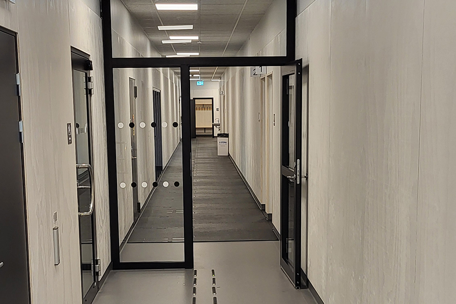 En korridor med en glasdörr som delar av korridoren halvvägs.