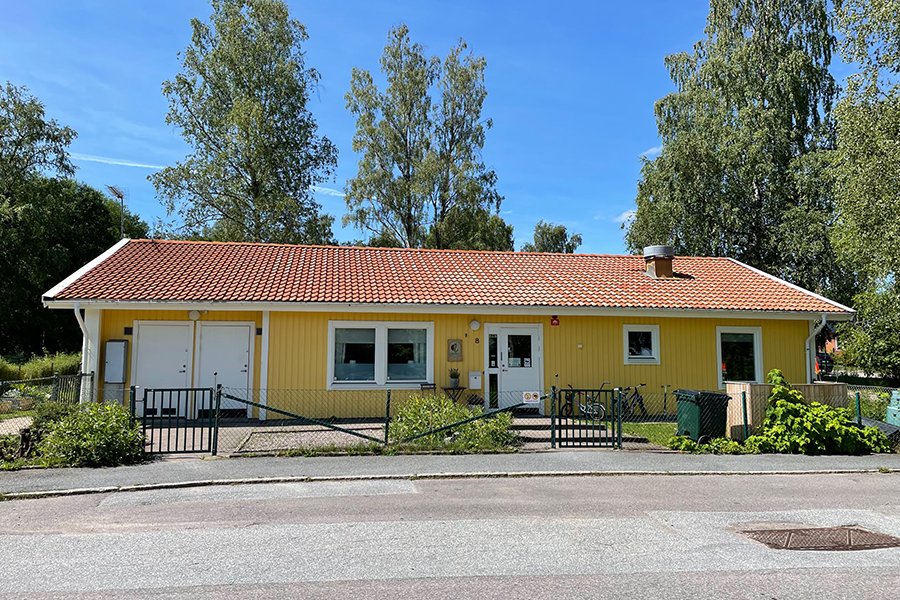 Granen i ur och skur förskola. En gul träbyggnad med vita knutar och röda tegelpannor med ett grönt staket runt byggnaden. 