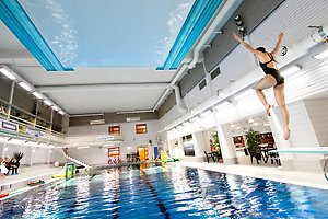 Ett tennisrack i närbild. Framför ligger en tennnisboll. 