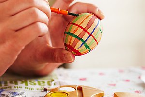 Ett tennisrack i närbild. Framför ligger en tennnisboll. 