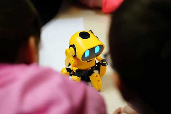 En gul robot med lysande blå ögon.